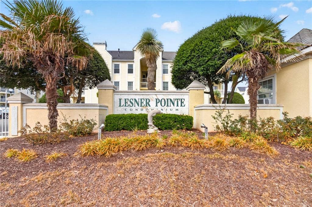 Lesner Pointe Condominium entrance sign with landscaped beds and the community buildings behind it in Chic's Beach, Virginia Beach. Community offers a pool, beach access, and gated entry. First-floor Unit 103 is offered here. 23451.