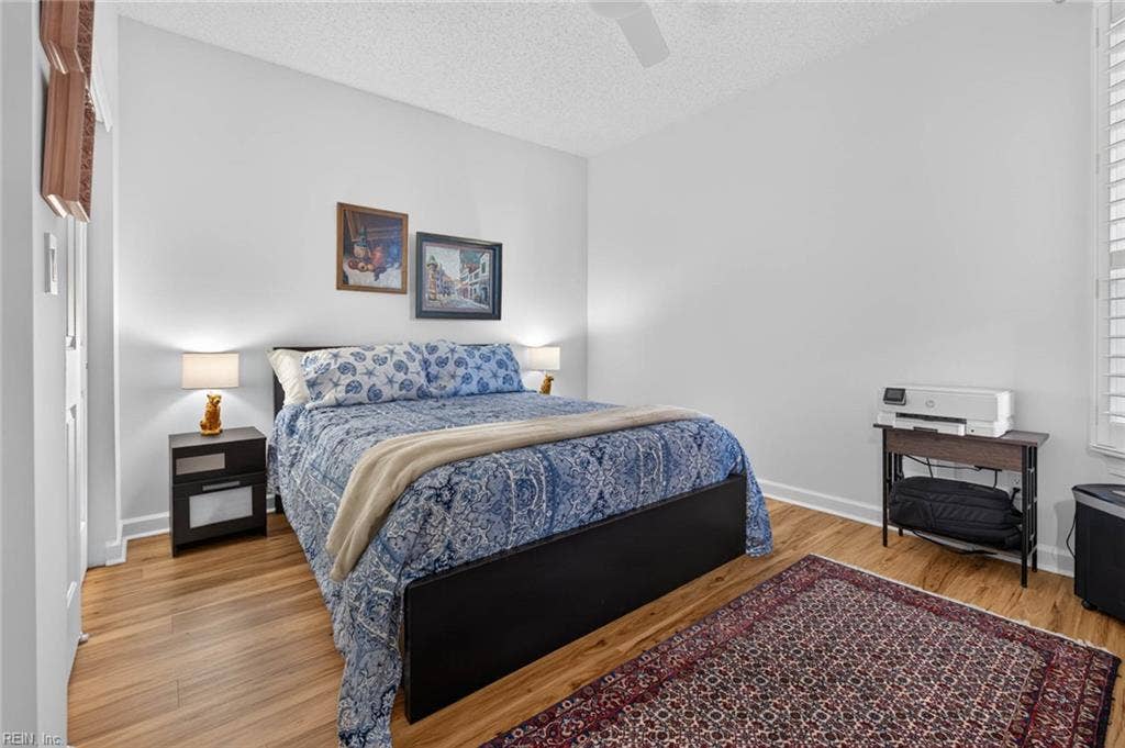 Second bedroom with ceiling fan, plantation shutters, closet, and LVP flooring in this 3 bedroom, 2 bath first-floor condo at Lesner Pointe, Chic's Beach, Virginia Beach. Room fits a king-size bed. 23451.
