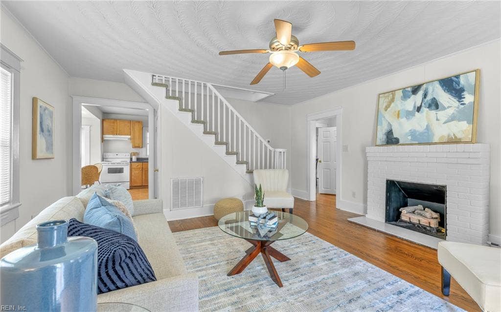 317 George Washington Highway S, Chesapeake, VA 23323 The living room flows directly into the kitchen, while the Craftsman-style staircase and railing add a strong architectural focal point at the center of it all.