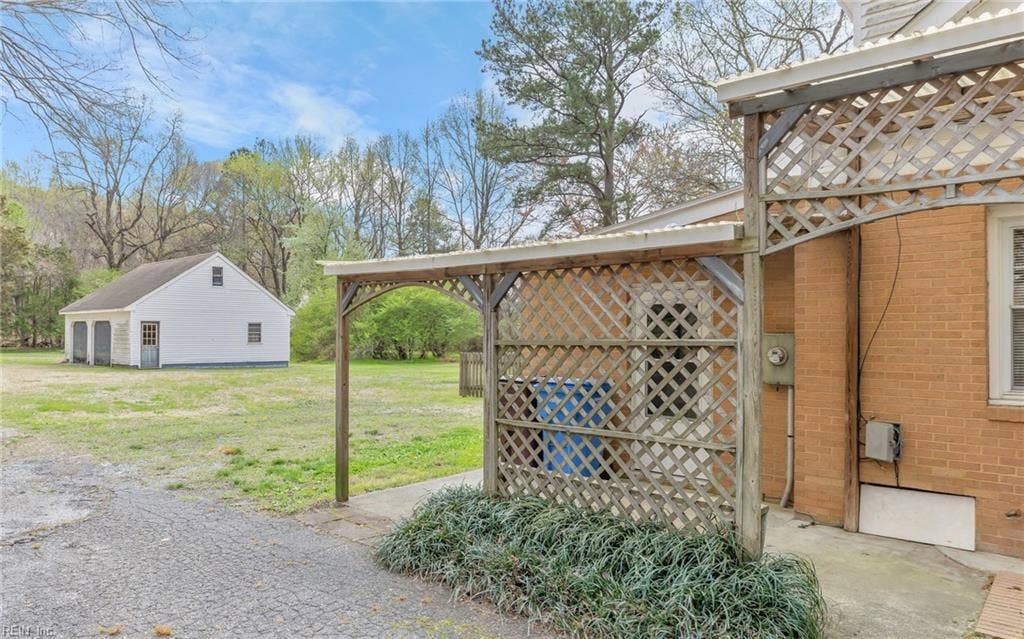 317 George Washington Highway S, Chesapeake, VA 23323 From the house, the detached garage/workshop sits just beyond the outdoor living area, reinforcing the property’s practical acreage layout.