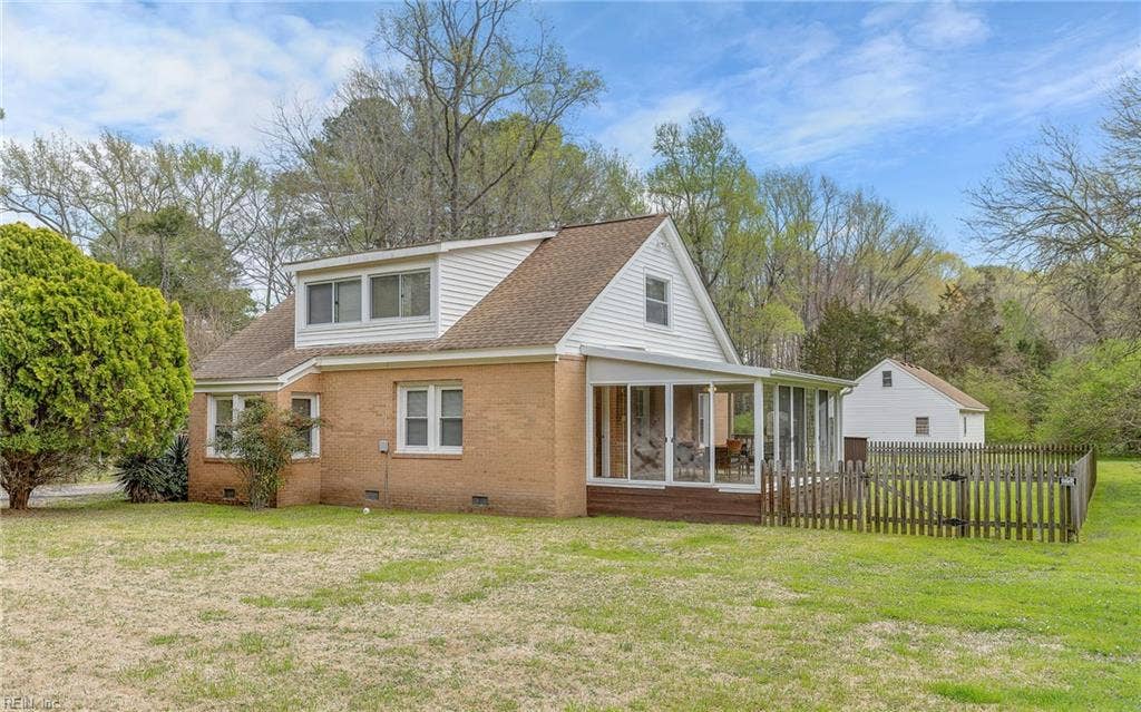 317 George Washington Highway S, Chesapeake, VA 23323 The home sits within an open yard with the detached garage/workshop visible beyond, reinforcing the flexibility of the property.