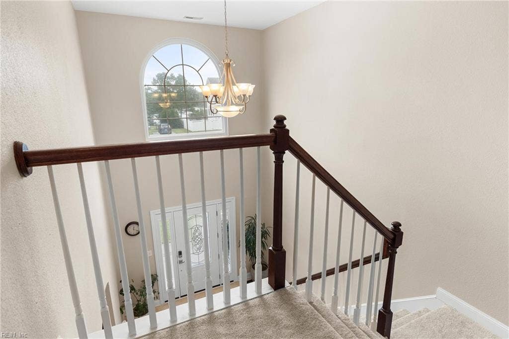 2309 Valle Rio Way, Virginia Beach, VA 23456 An upstairs overlook frames the two-story foyer, where an arched window fills the entry with natural light and decorative railings add custom character.