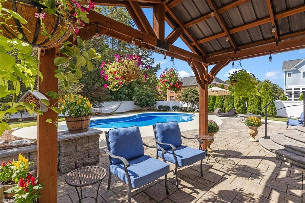 2309 Valle Rio Way, Virginia Beach, VA 23456 Covered seating + lighting beside the pool creates a perfect retreat for morning coffee and relaxed outdoor entertaining.