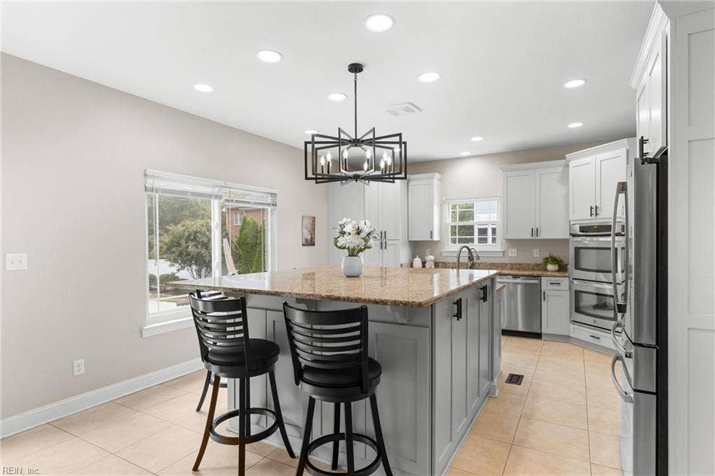 2309 Valle Rio Way, Virginia Beach, VA 23456 Refreshed custom cabinetry, oversized island featuring granite countertops, matte black hardware and the updated lighting create a kitchen made for gathering.