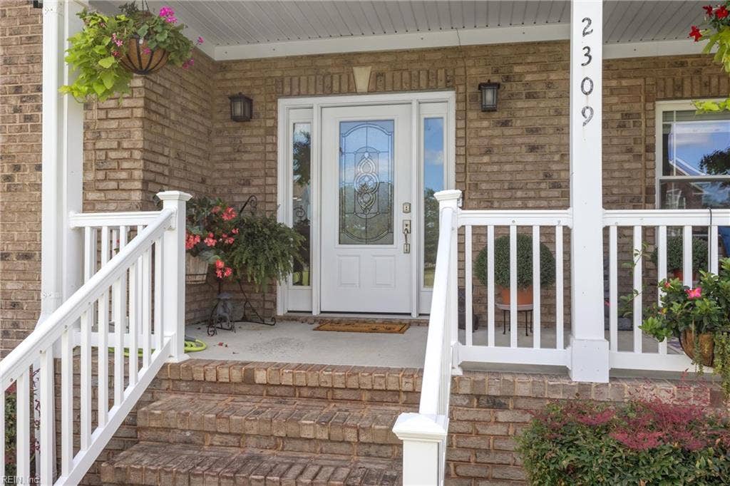 2309 Valle Rio Way, Virginia Beach, VA 23456 An inviting + deep covered front porch offers space to sit, unwind and enjoy the view toward the water.