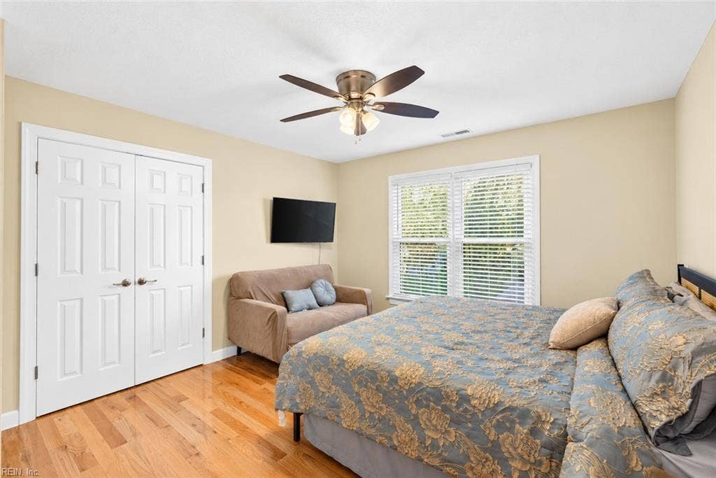 Comfortable secondary bedroom with hardwood floors and abundant natural light