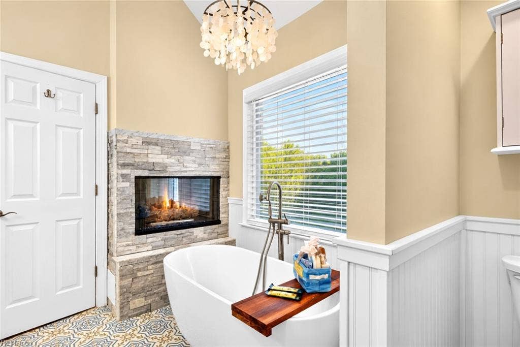 Spa-inspired primary bath with soaking tub and double-sided fireplace