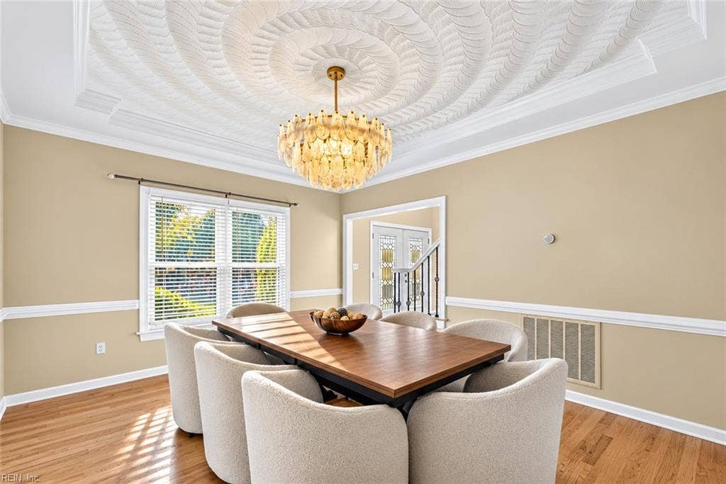 Elegant formal dining room with statement lighting and detailed ceiling