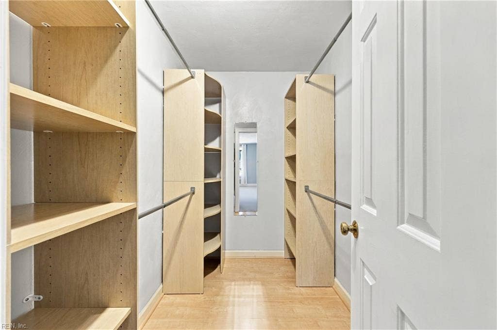 Primary closet complete with wooden built-ins.
