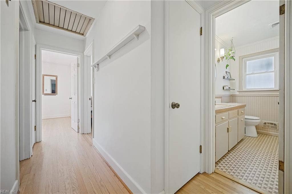 Hallway with wood flooring, hall closet and linen closet