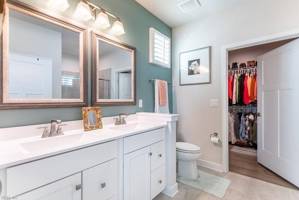 Primary bathroom with double vanity and walk in closet