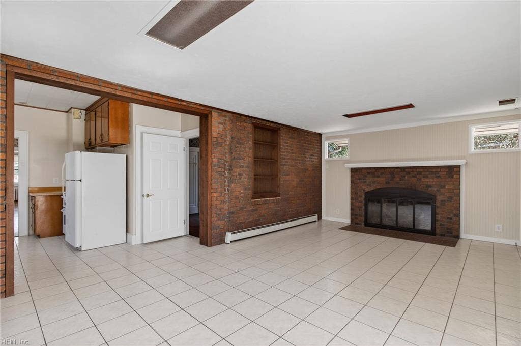 Large family room with second wood fireplace; off of kitchen with access to basement out of view