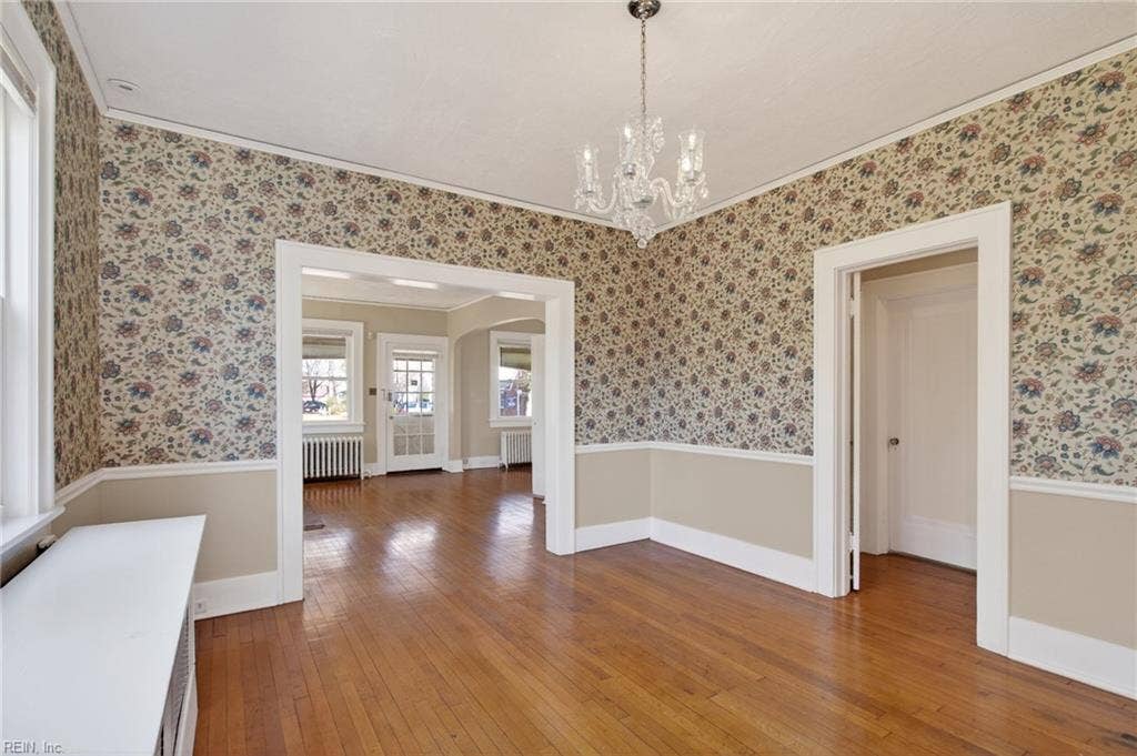 Wood flooring in formal dining room extends into hallway and bedrooms