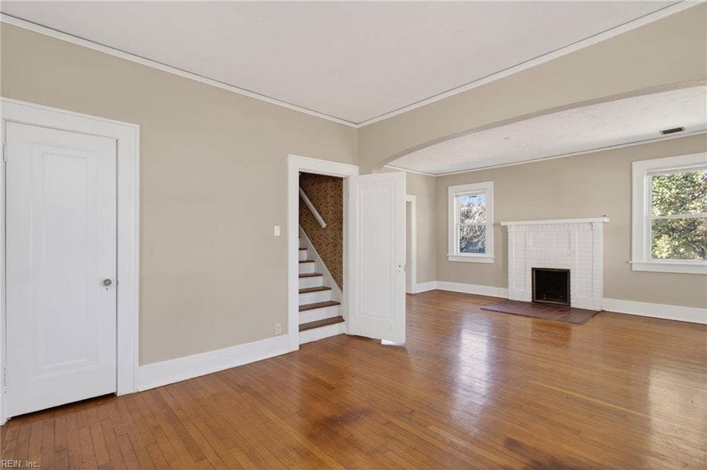 Front living room viewed from adjacent sitting room with stairs to second floor