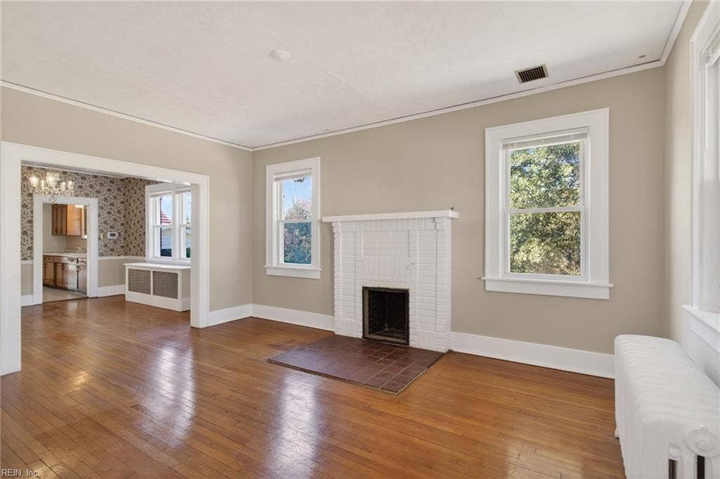Front living room with wood fireplace opens to formal dining room
