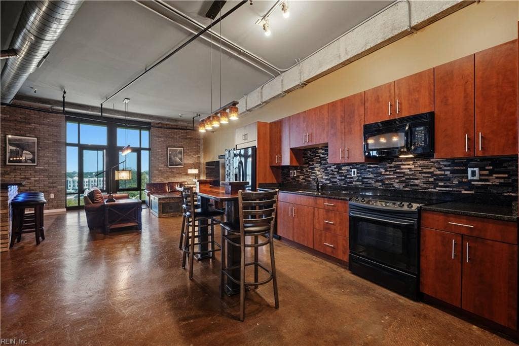 Solid wood cabinetry, granite countertops and sleek black appliances. Another unique light fixture