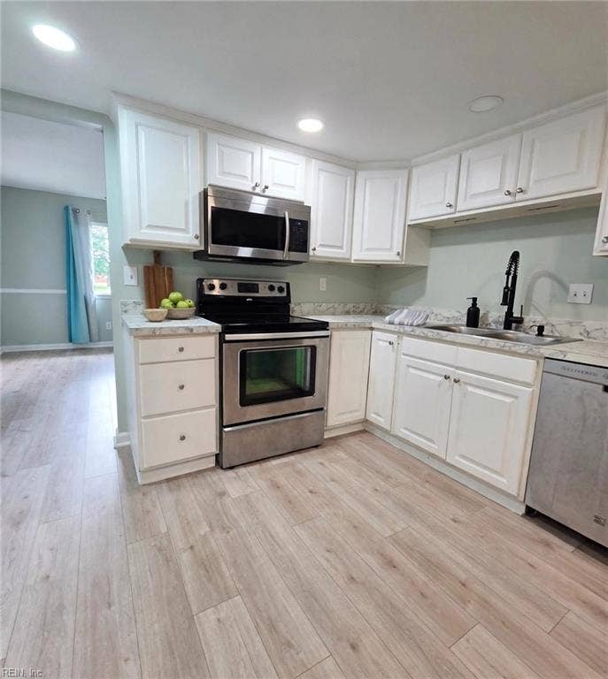 Updated kitchen: white cabinets, stainless appliances, marble-look counters. Virtually staged.
