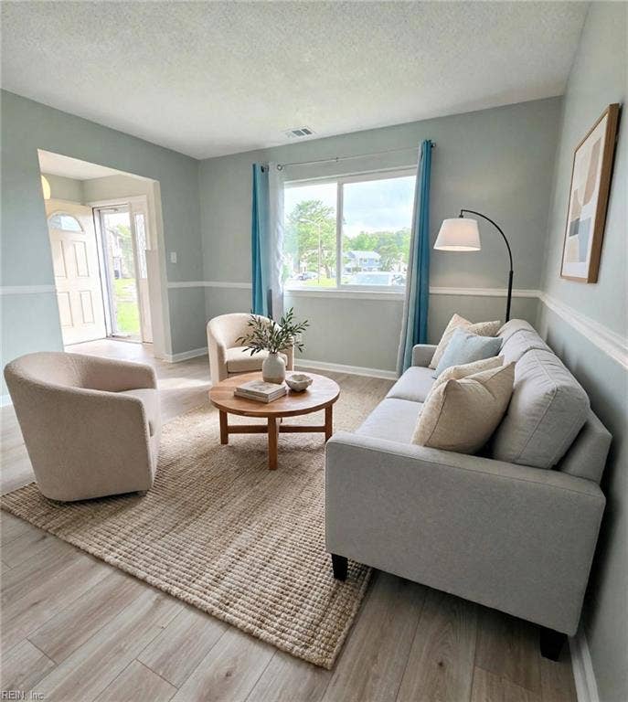 Formal living room with big windows and tons of natural light. Virtually staged.