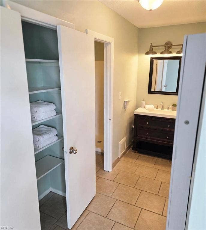En-suite bath with linen closet. Virtually staged