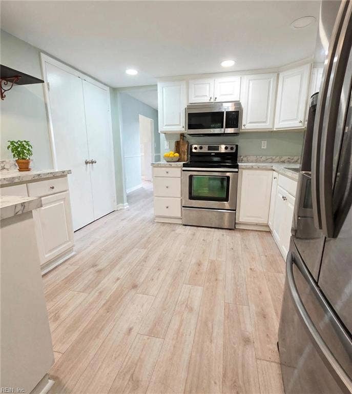 Updated kitchen: white cabinets, stainless appliances, marble-look counters. Virtually staged.