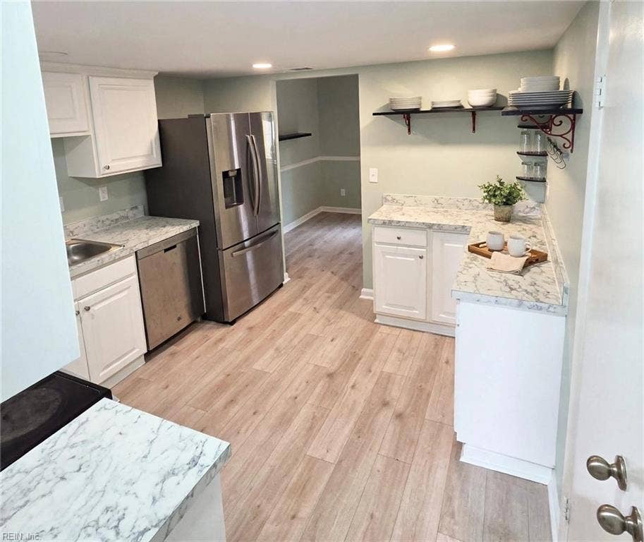 Updated kitchen: white cabinets, stainless appliances, marble-look counters. Virtually staged.