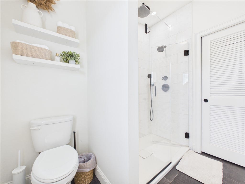 36 Bellevue Avenue, North Smithfield, RI 02896 Additional view of the primary bathroom showing the glass-enclosed shower, modern fixtures, floating shelves, and bright neutral finishes.