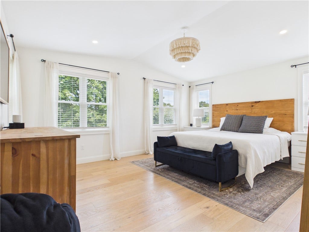 36 Bellevue Avenue, North Smithfield, RI 02896 Spacious primary bedroom at 36 Bellevue Avenue in North Smithfield, RI, featuring abundant natural light, hardwood flooring, and a bright, airy feel.