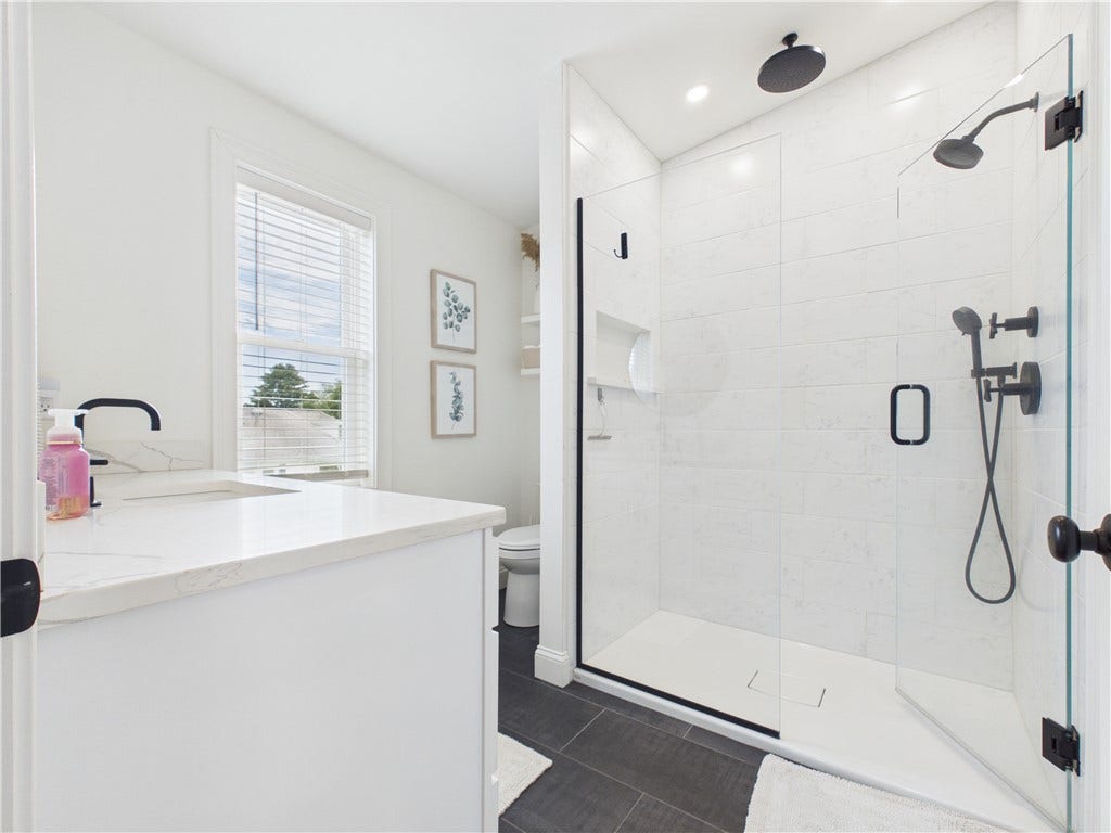 36 Bellevue Avenue, North Smithfield, RI 02896 Primary en suite bath featuring a large glass-enclosed tiled shower with matte black fixtures and a clean, modern finish.