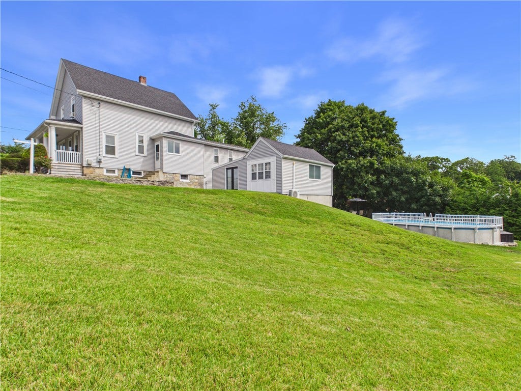 36 Bellevue Avenue, North Smithfield, RI 02896 Side exterior and backyard view featuring the above-ground pool at 36 Bellevue Avenue, situated on an approximately 14,941-square-foot lot in North Smithfield, RI.