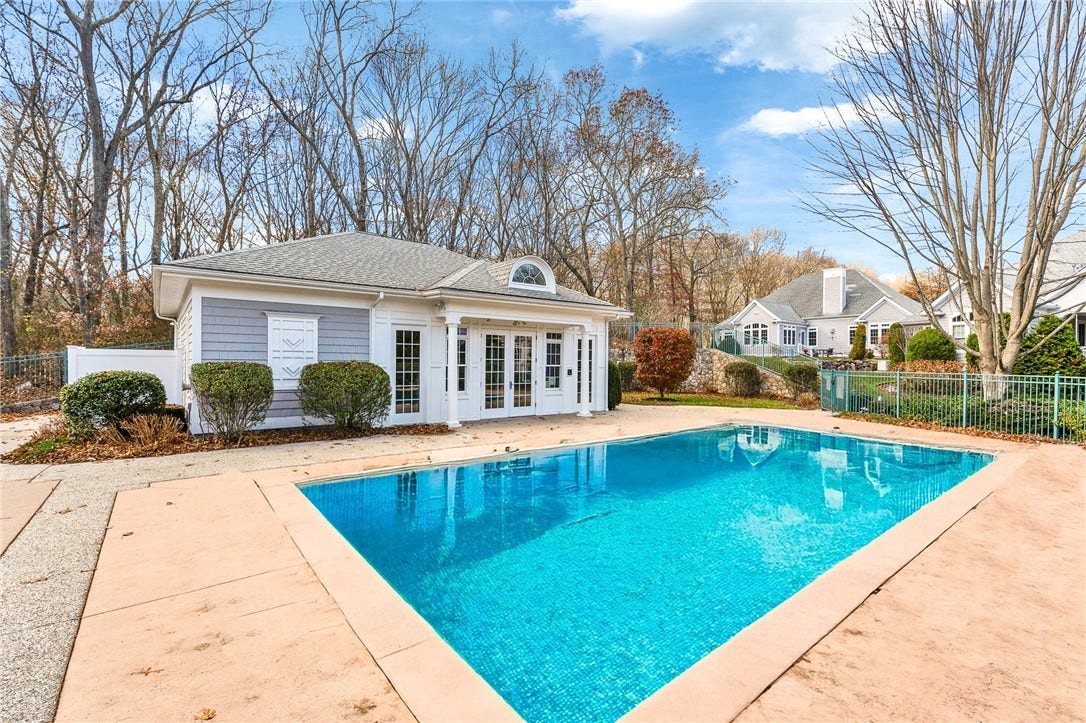 95 Fry Brook Drive, East Greenwich, RI 02818 Inviting community pool surrounded by a spacious patio and complemented by an attactive clubhouse, all set against a peaceful wooded backdrop.