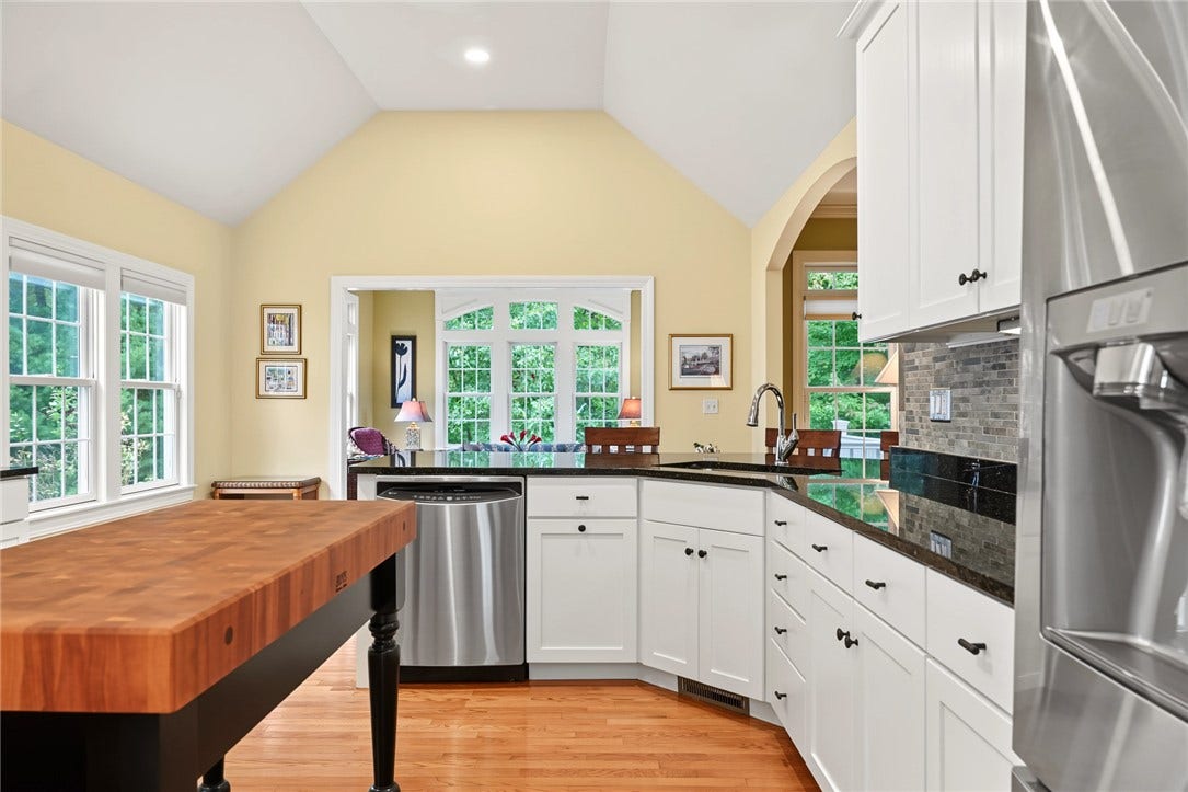 95 Fry Brook Drive, East Greenwich, RI 02818 The inviting kitchen flows to the sunroom and deck and is framed by expansive windows.