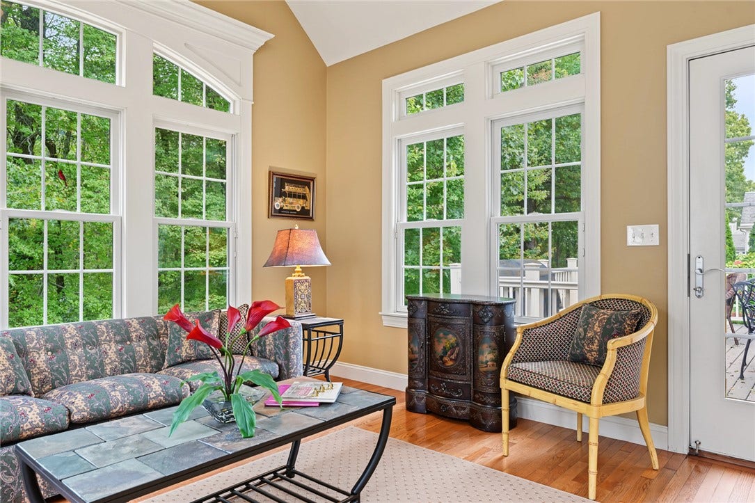 95 Fry Brook Drive, East Greenwich, RI 02818 A dramatic, sun-filled room featuring vaulted ceilings and walls of oversized windows. Direct access from the sun room to the deck for easy entertaining.