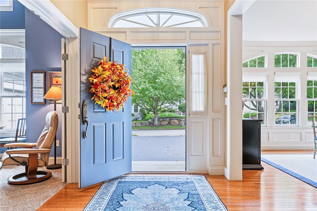 95 Fry Brook Drive, East Greenwich, RI 02818 A gracious, light-filled entry welcomes you with gleaming hardwood floors, elegant architectural millwork, and a dramatic arched transom above the front door creating a sophisticated first impression.