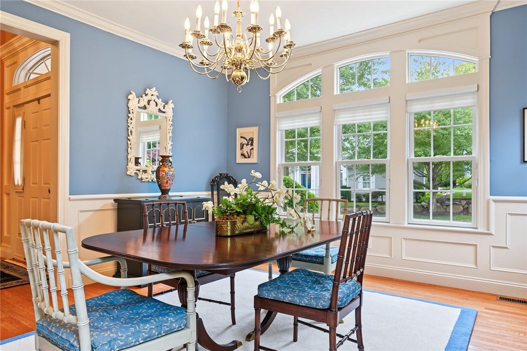 95 Fry Brook Drive, East Greenwich, RI 02818 This formal dining room is highlighted by soaring ceilings, dramatic oversized windows, classic wainscoting and a statement chandelier, creating a light-filled setting for entertaining.