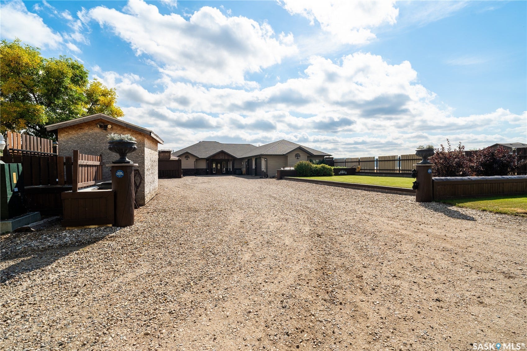 Front of property with gravel drive, shed and lawn