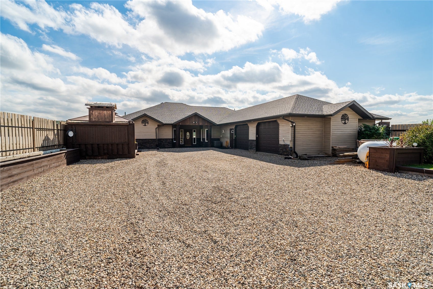 front of house with bbq shack and attached garage. gravel drive