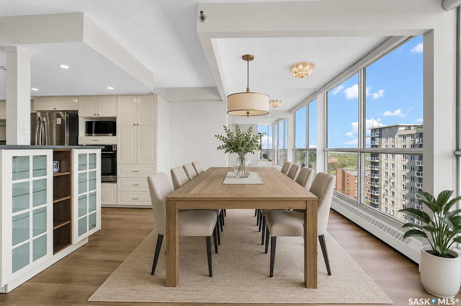 Open-concept living area with extensive window walls, recessed lighting, and wood-finish flooring