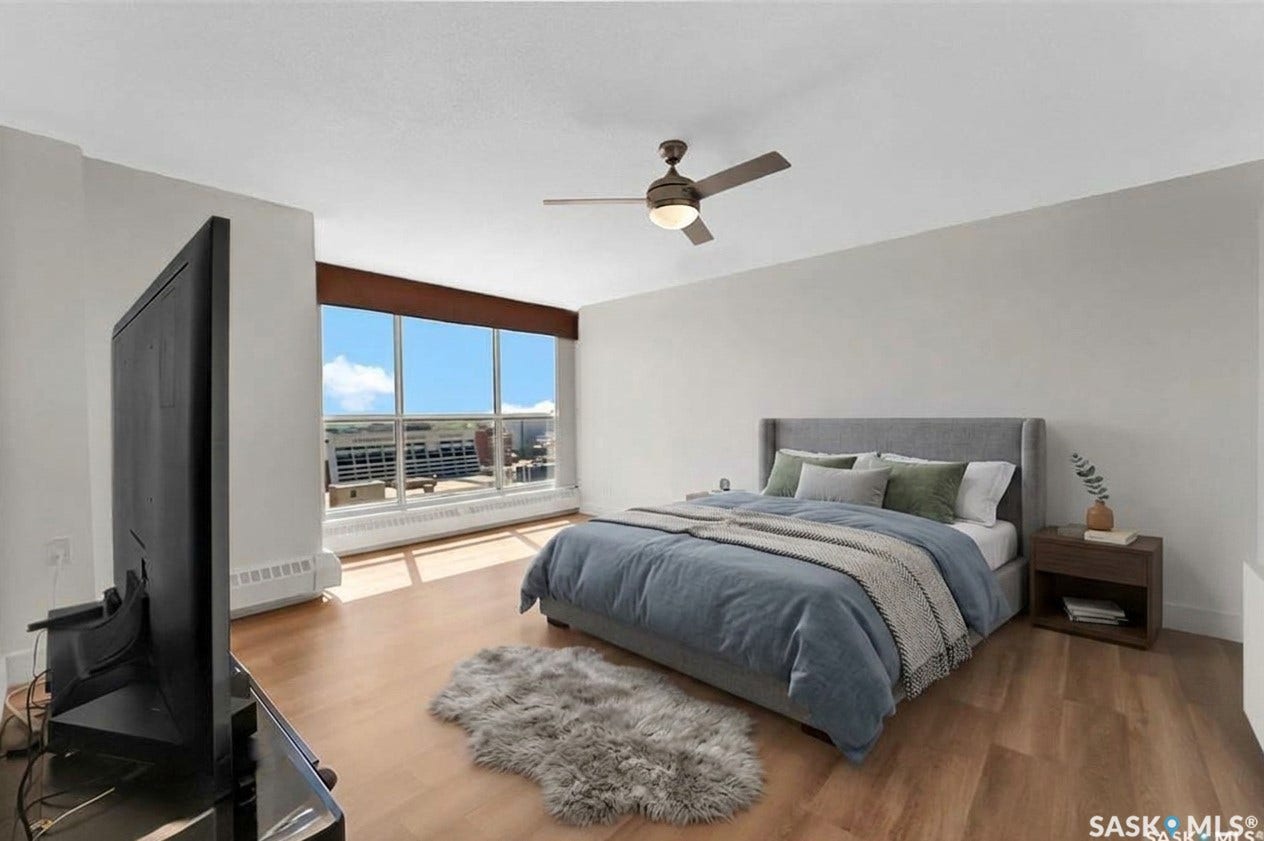Expansive floor-to-ceiling windows, wood-finish flooring, and a ceiling fan with integrated lighting