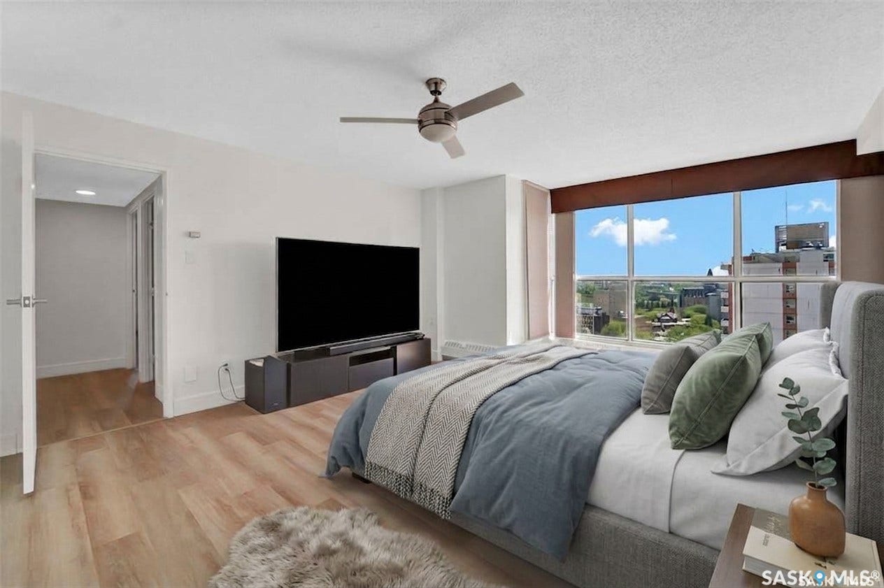 Expansive window wall, wood-finish flooring, ceiling fan, and built-in media console