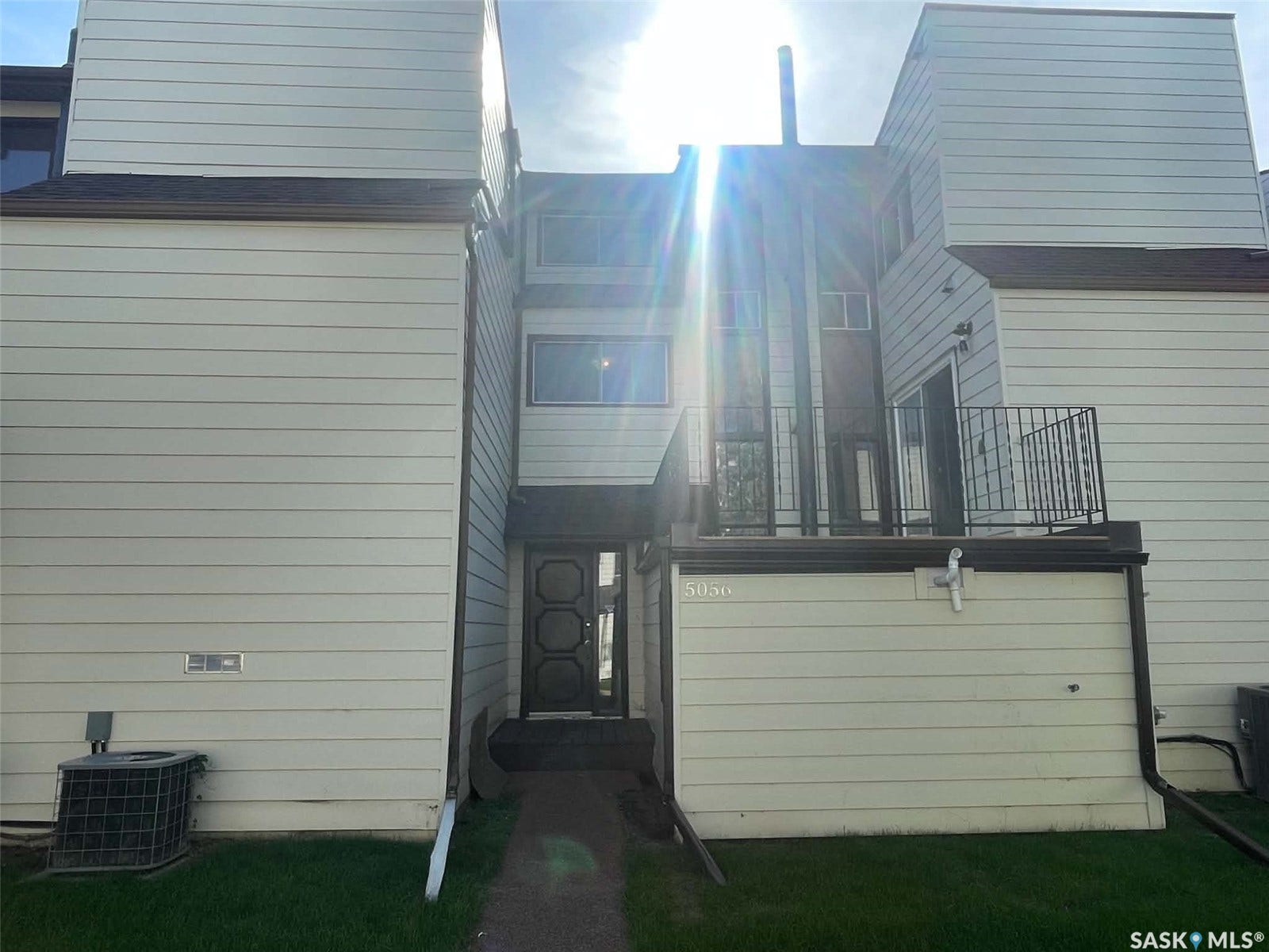 Multi-level facade with horizontal siding, dark trim, and a prominent front entry
