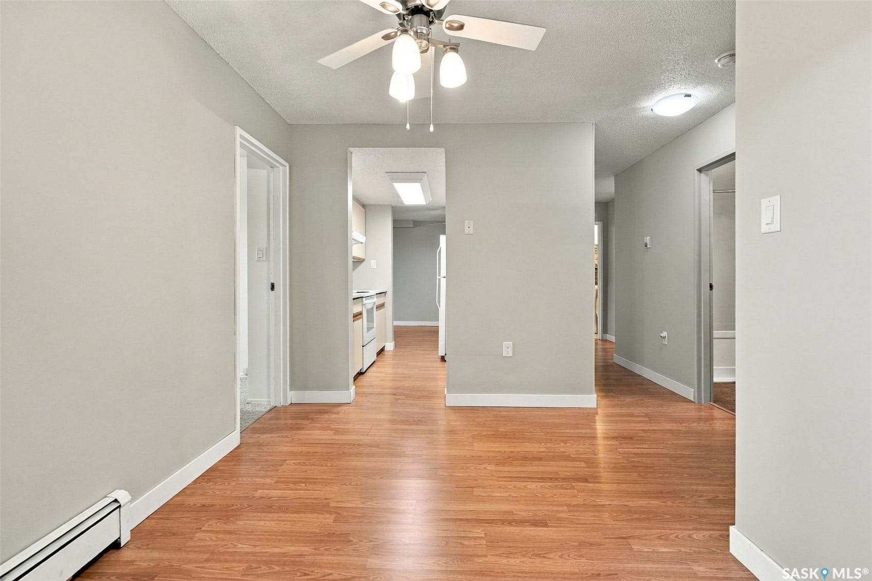 3410 Park Street, #119, Regina SK S4V 2M8 Wood-finish flooring throughout, light gray wall paint, and overhead lighting