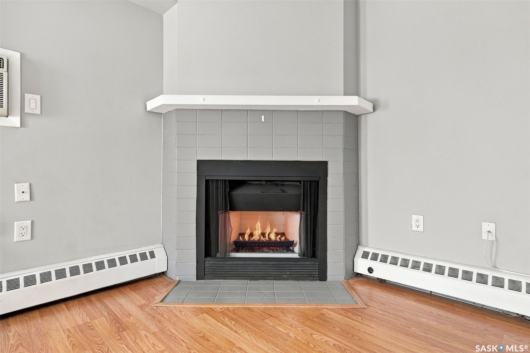 3410 Park Street, #119, Regina SK S4V 2M8 Corner fireplace with a tile surround and hearth, featuring a white mantel shelf