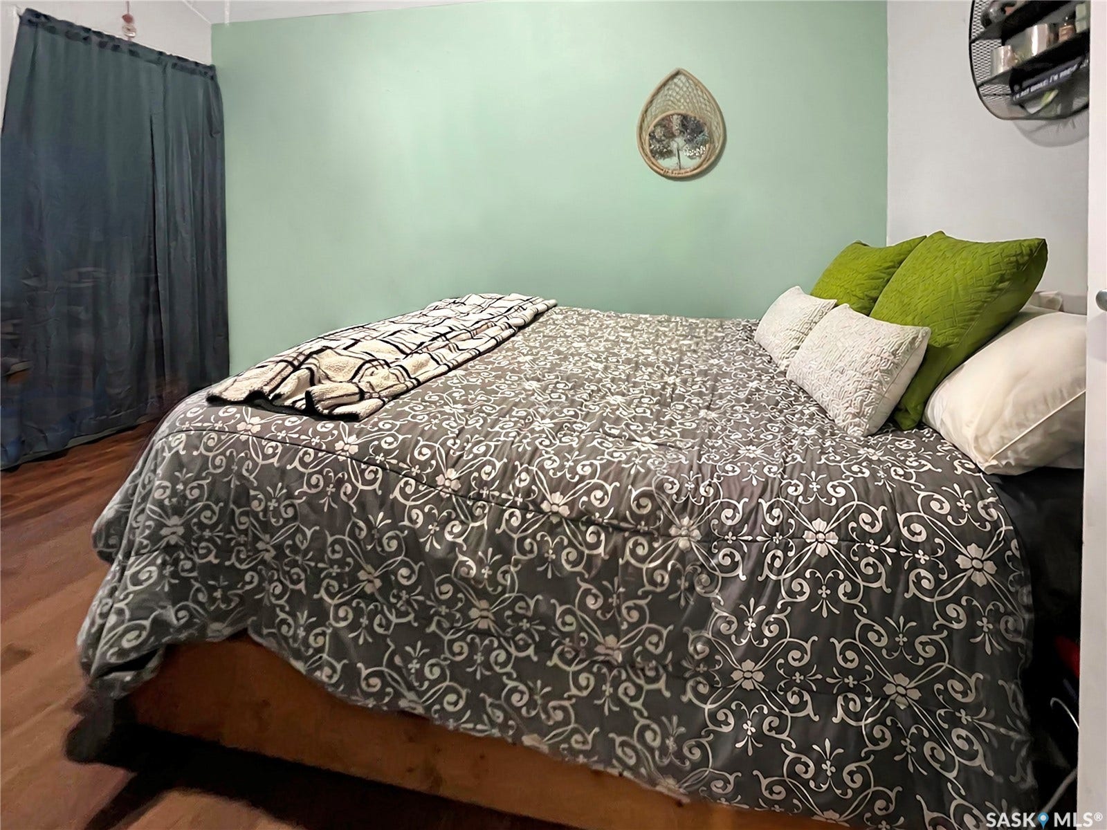 Wood-finish flooring with light green wall treatment.