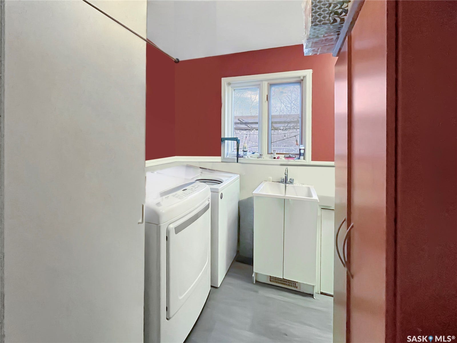Utility room featuring a utility sink, a window, and built-in cabinetry