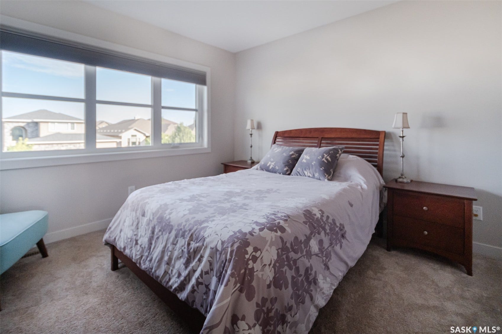 Expansive window with white trim, soft gray wall paint, and light-toned carpet flooring