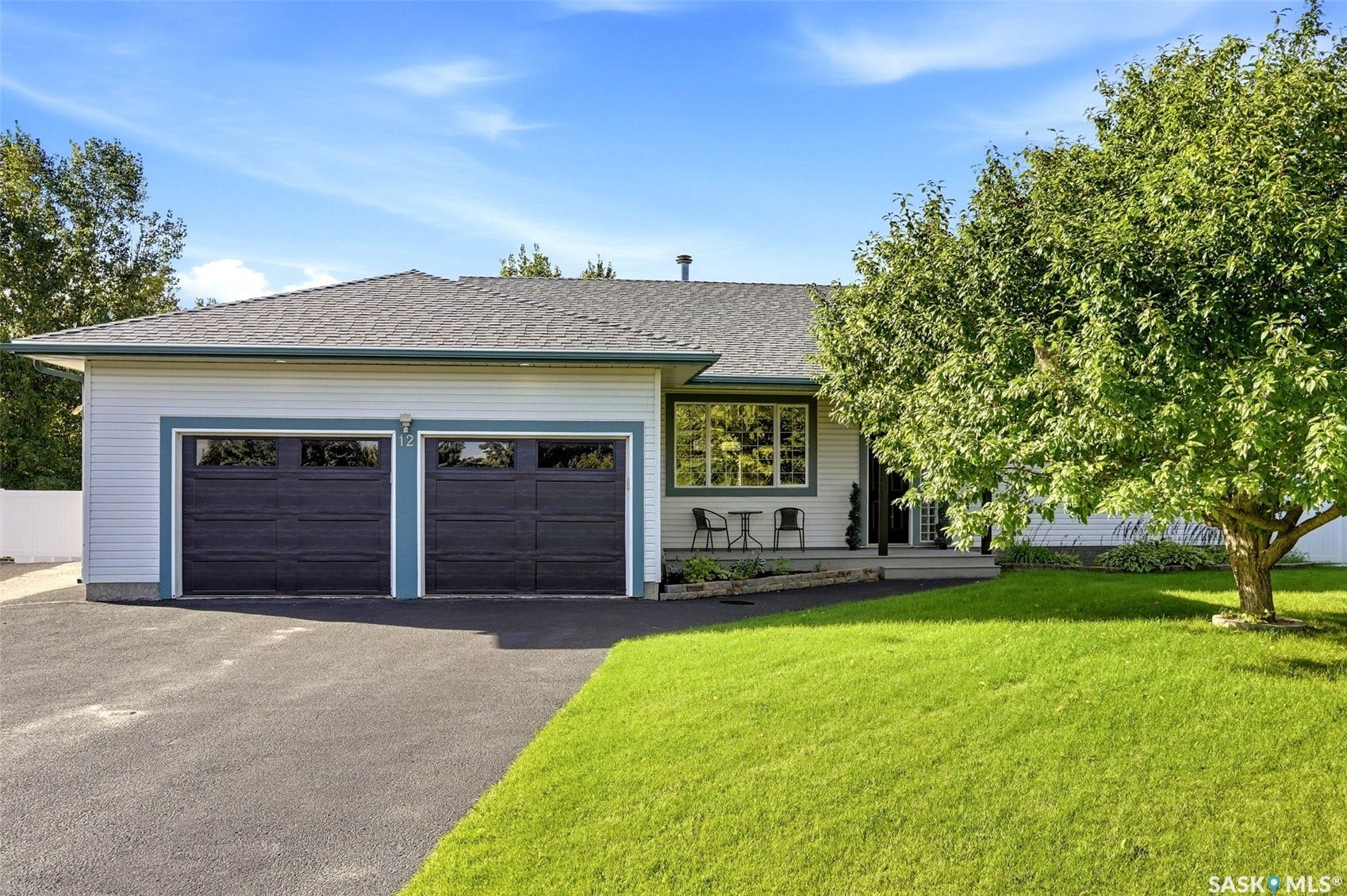 Ranch-style exterior with light siding, a dark asphalt shingle roof, and a two-car garage with dark paneled doors
