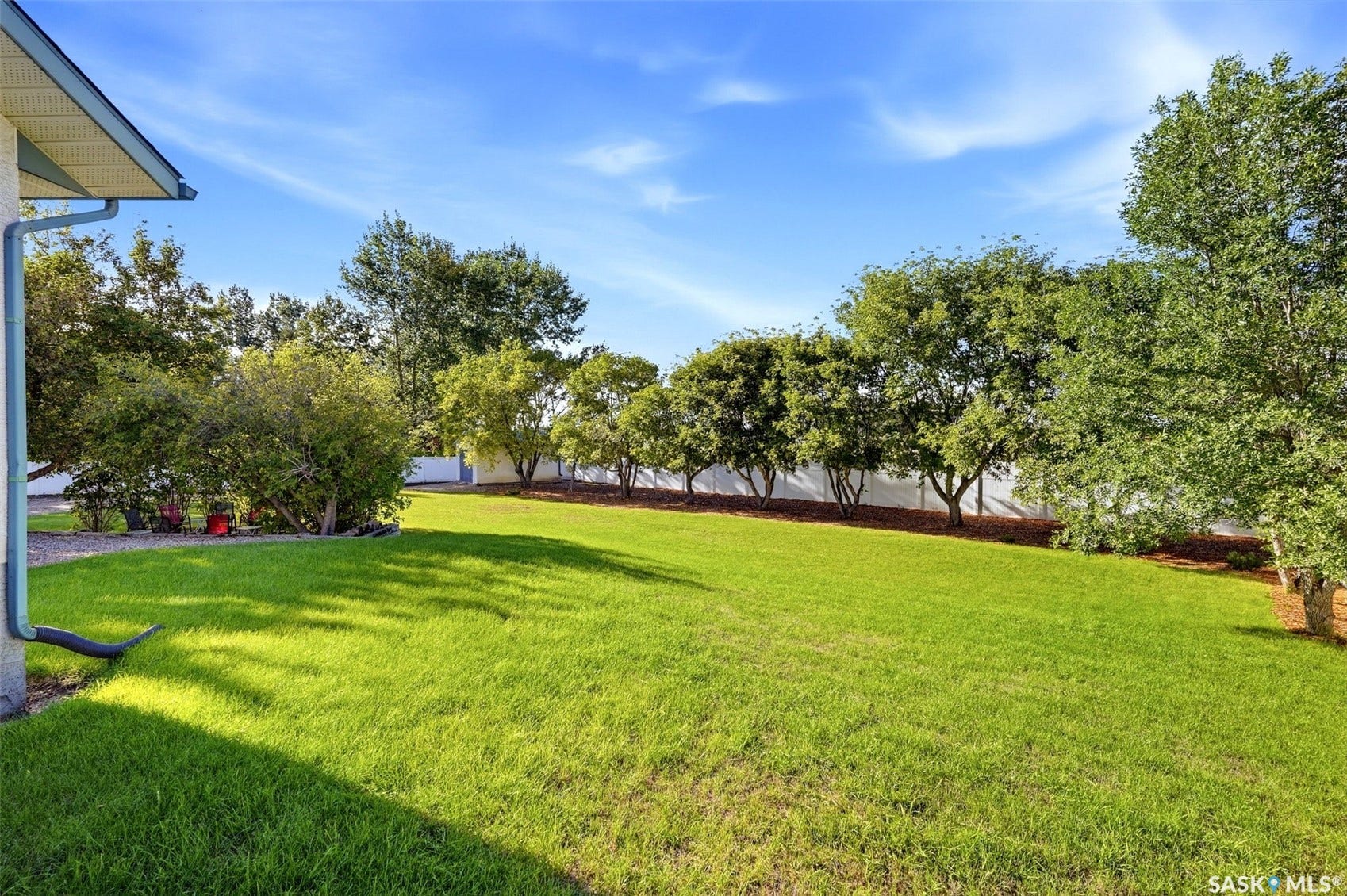 Expansive lawn area, mature trees, and a perimeter fence