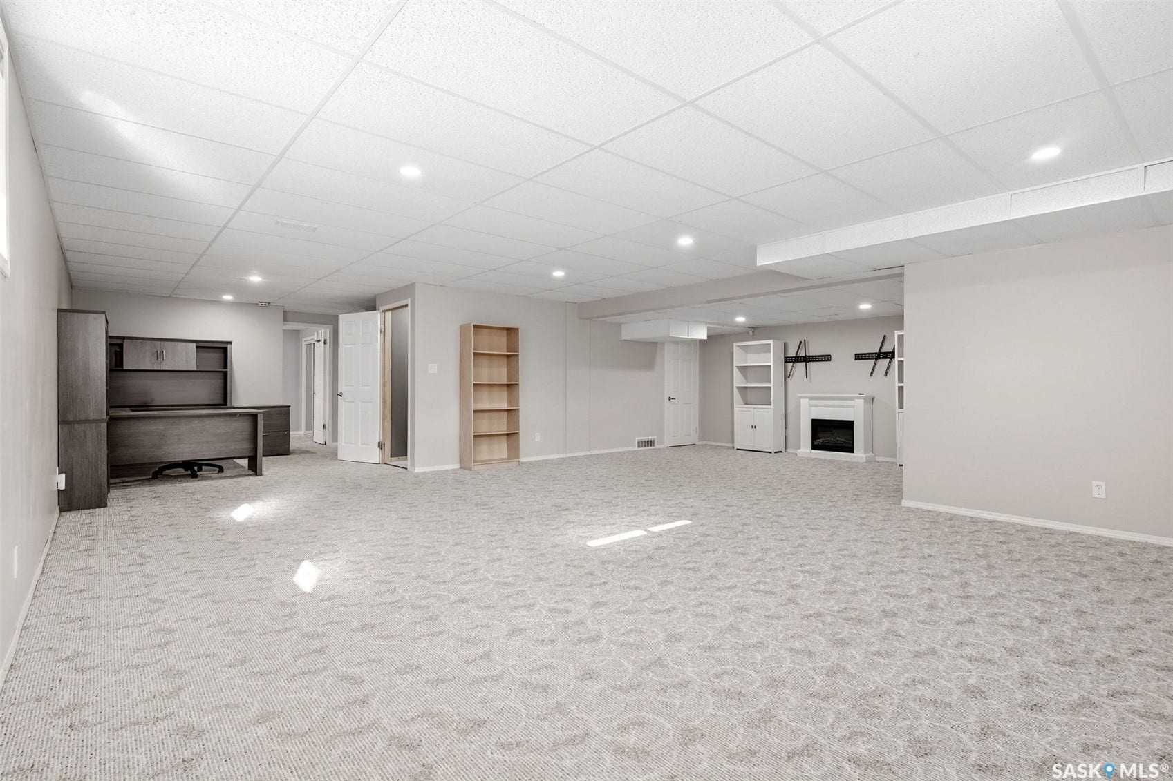 Spacious finished room with recessed lighting, patterned carpet flooring, and a built-in fireplace