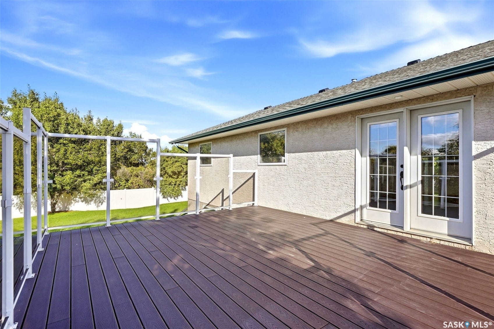 Expansive deck featuring dark composite decking and glass panel railings