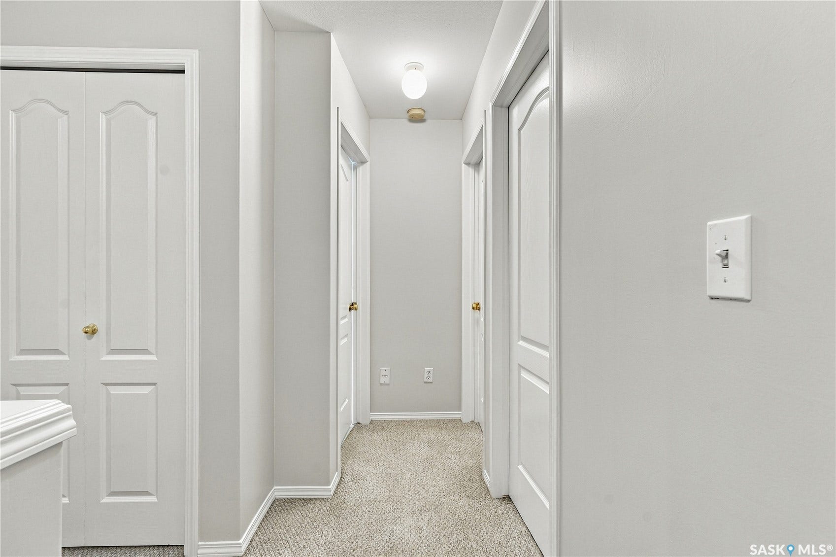 Hallway with light gray wall paint, white trim, and carpet flooring